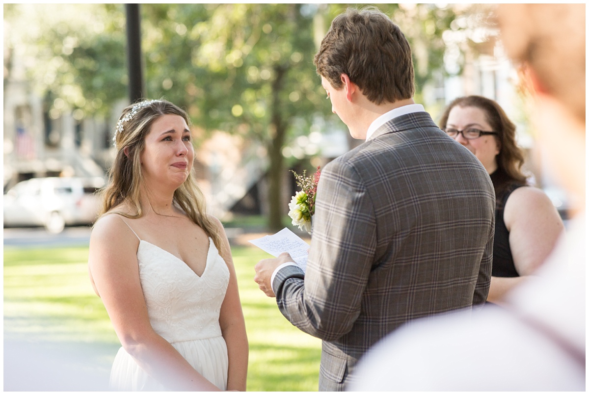 bride crying as husband reads vows